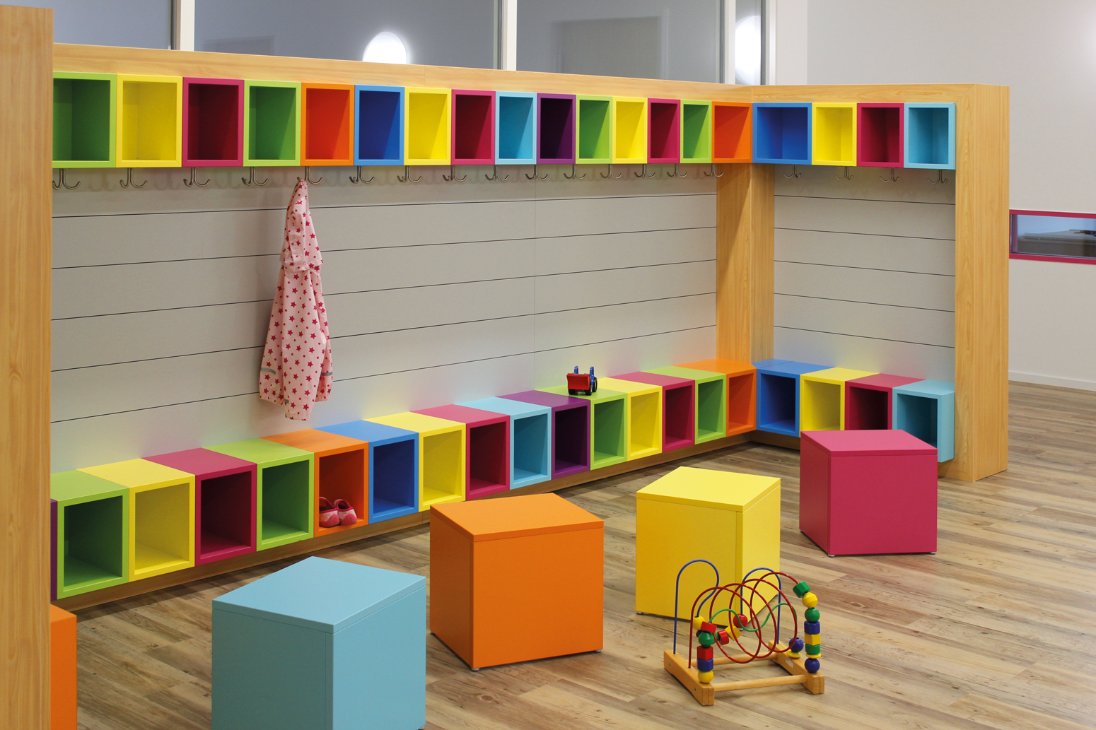 Alles schön bunt hier: 
Kindergarderobe mit Sitzbank, Schuhablage, Ablagefach oben und Garderobenhaken.